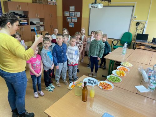 Nauczycielka prezentuje przedszkolakom sposób przyrządzania wody smakowej