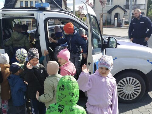 Dzieci oglądają samochód policyjny od środka